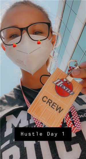 Alex with mask, holding Crew badge